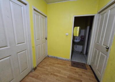 A hallway with yellow walls and three doors.