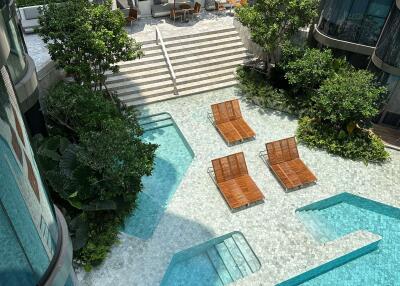 Outdoor pool area with lounge chairs and greenery