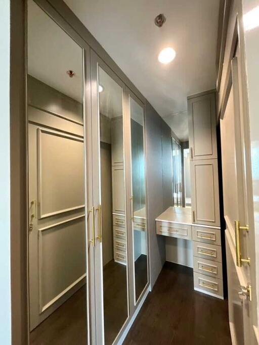 Spacious walk-in closet with mirrored doors and ample storage