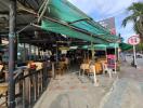 Outdoor seating area of a cafe with wicker chairs and tables