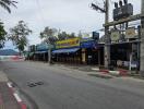 Street view of a commercial area with storefronts and outdoor seating