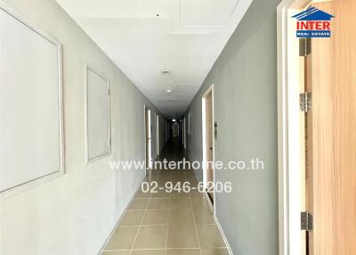 Long hallway in a building with multiple doors and tiled flooring.