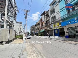 Street view of a residential and commercial area with multi-story buildings