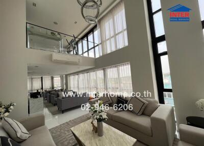 Modern living room with high ceiling and large windows