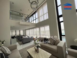 Modern living room with high ceiling and large windows