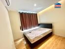 Bedroom with a double bed, brown curtains, wooden floor, and an air conditioner.