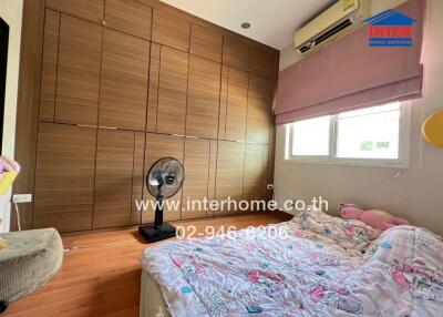 Spacious bedroom with large wooden wardrobe, window, air conditioner, and cozy bed