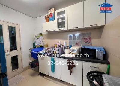 Small kitchen with various appliances and storage cabinets