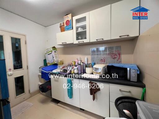 Small kitchen with various appliances and storage cabinets