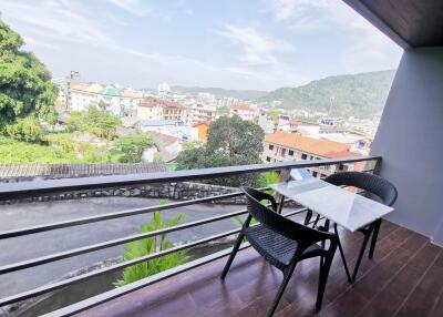 Balcony with a table, chairs, and a scenic view of the city and mountains