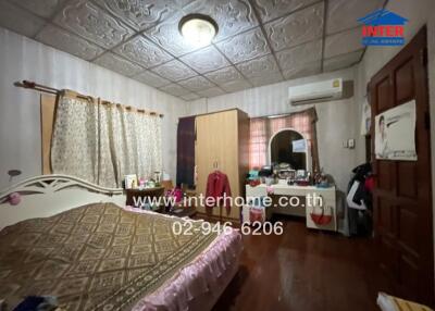 Bedroom with bed, wardrobe, window with curtains, and air conditioning unit
