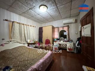 Bedroom with bed, wardrobe, window with curtains, and air conditioning unit