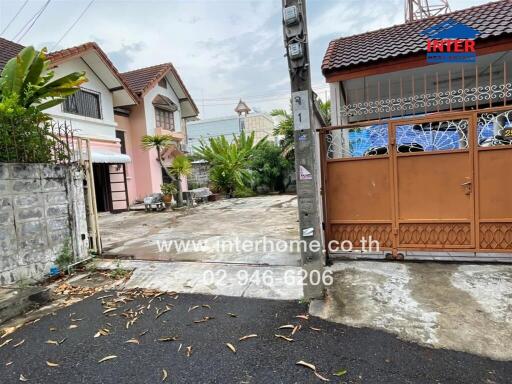 Exterior view of a property with driveway and entrance gate