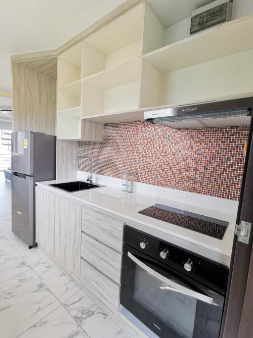 Modern kitchen with built-in appliances and tiled backsplash