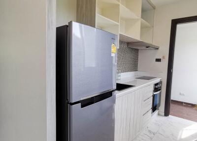 Modern kitchen with stainless steel fridge, built-in oven, and shelving