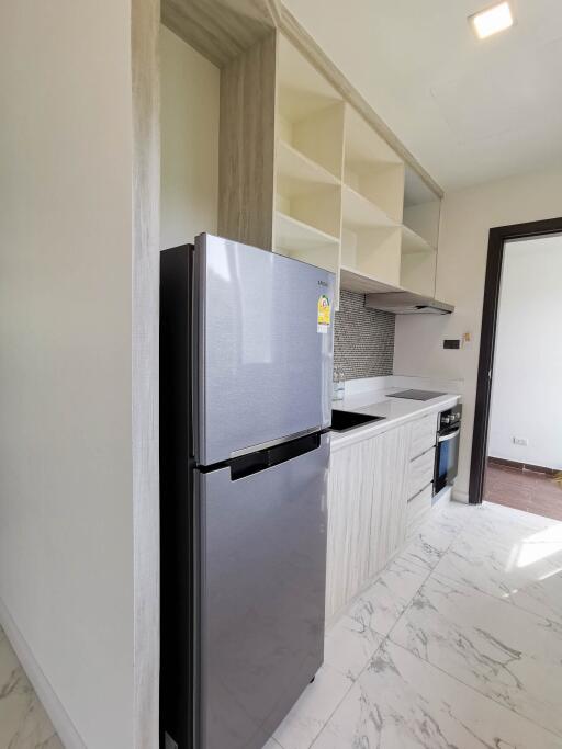 Modern kitchen with stainless steel fridge, built-in oven, and shelving