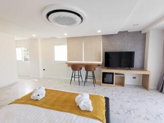 Modern bedroom with bed, TV, and seating area