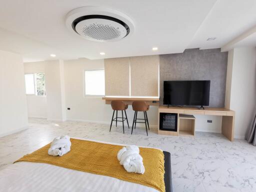 Modern bedroom with bed, TV, and seating area