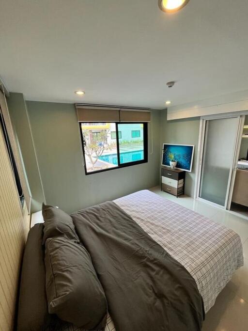 Modern bedroom with large windows and a TV