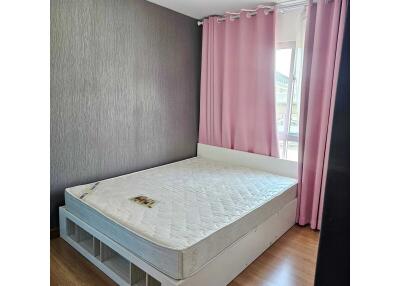 A bedroom with a bed and pink curtains