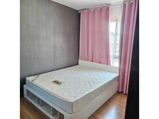 A bedroom with a bed and pink curtains