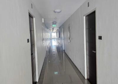 Long corridor with multiple doors and bright ceiling lights