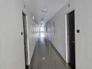 Long corridor with multiple doors and bright ceiling lights