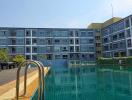 Outdoor swimming pool with apartment building in background