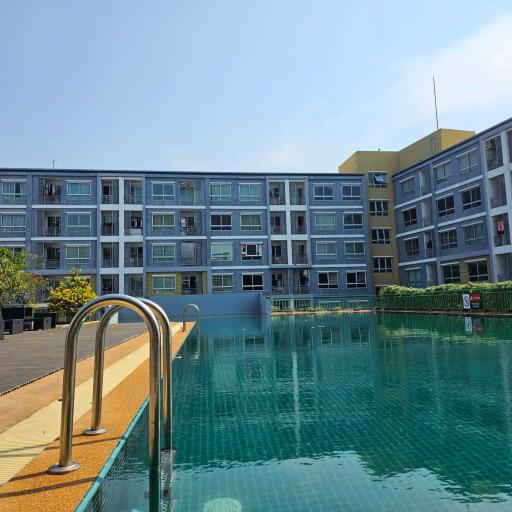 Outdoor swimming pool with apartment building in background