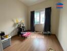 Bedroom with hardwood floor, black curtains, and a small shelf