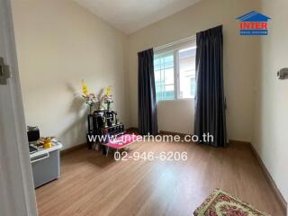 Small bedroom with wooden floor, natural light, window, and simple decor