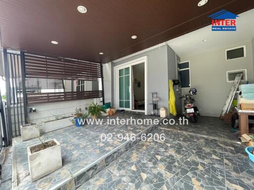 Covered outdoor area with tiled flooring and plants
