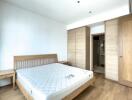 Spacious bedroom with a wooden bed frame, mattress, and built-in wardrobes