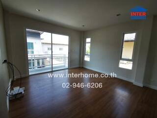 Spacious living room with wooden flooring and large windows