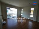 Spacious living room with wooden flooring and large windows