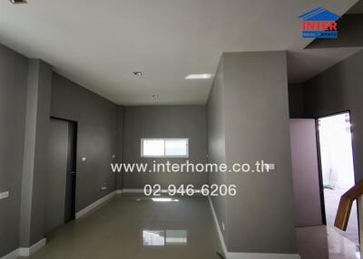 Spacious modern living room with tiled flooring, grey walls, and recessed lighting