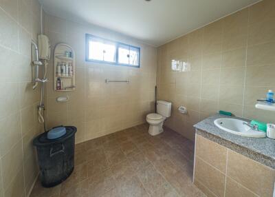Spacious bathroom with toilet, sink, and shower