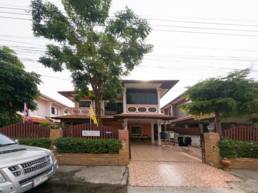 Front view of a residential house with trees and driveway