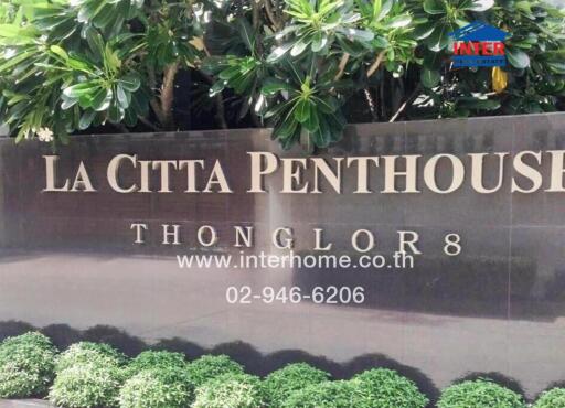 La Citta Penthouse entrance sign with lush greenery