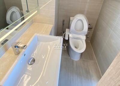 Clean modern bathroom with large white sink and toilet