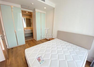 Modern bedroom with large bed, wooden floors, and built-in wardrobe