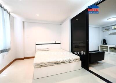 Spacious bedroom with adjacent living area and large window