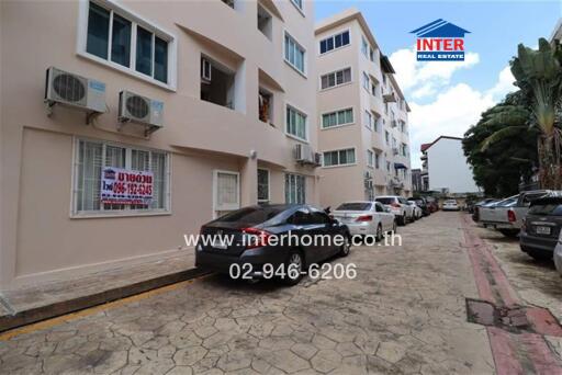 Front view of a residential building with parking area