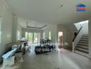 Spacious living room with staircase and large windows