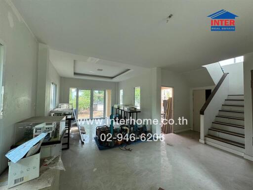 Spacious living room with staircase and large windows