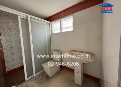 Bathroom with toilet, sink, and shower area