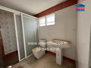 Bathroom with toilet, sink, and shower area