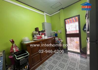 Small kitchen with green walls and a windowed door to the outside