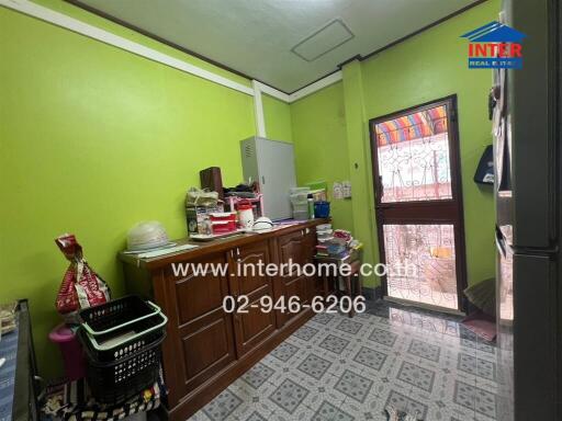 Small kitchen with green walls and a windowed door to the outside
