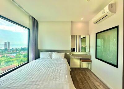 Well-lit bedroom with large windows and a view